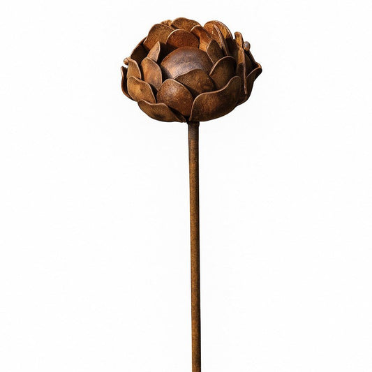 Handcrafted rusted metal peony garden stake with sculptural flower head, placed in a cottage-style UK garden as a decorative outdoor ornament