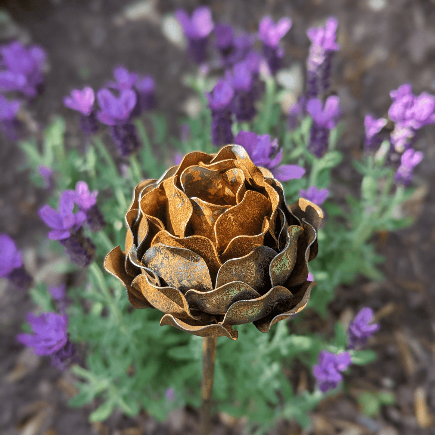 Artisan-crafted rusted metal peony garden stake with layered petals and sculptural detail, styled in a heritage-inspired UK garden setting