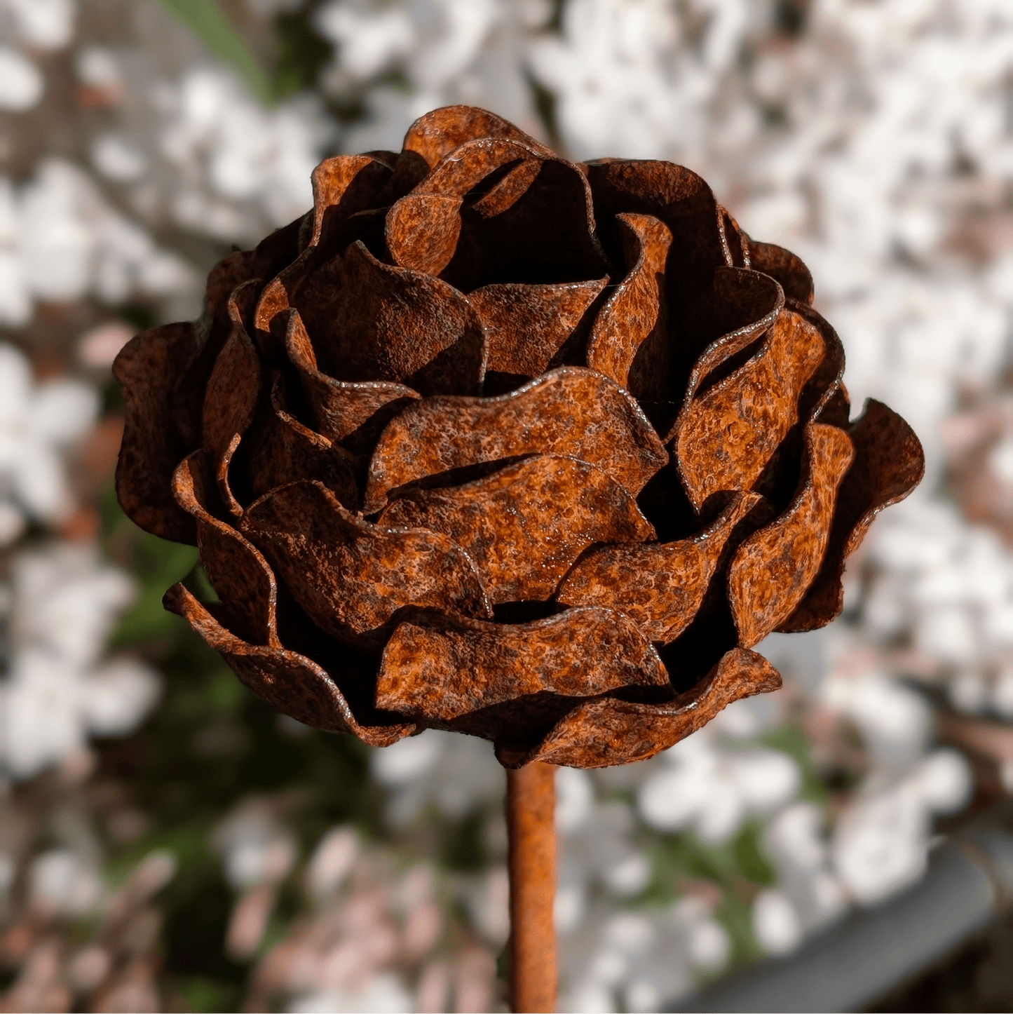 Handcrafted rusted metal peony garden stake with layered petals and sculptural charm, styled in a heritage-inspired UK garden border