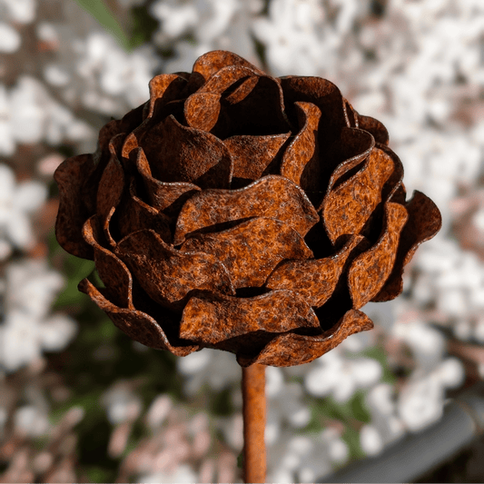 Handcrafted rusted metal peony garden stake with layered petals and sculptural charm, styled in a heritage-inspired UK garden border