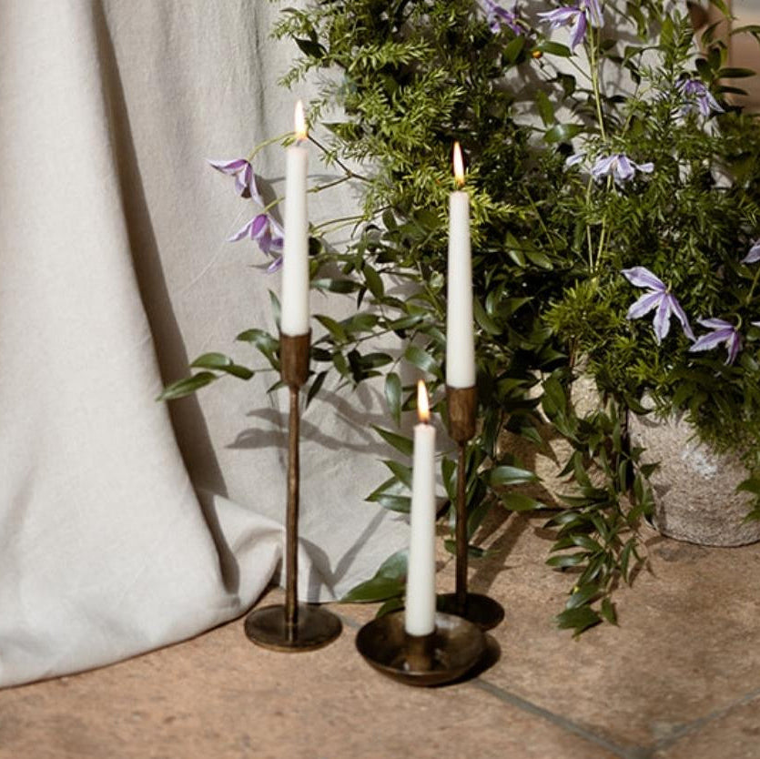 Brambourne candle holder styled with two tall taper candles in a ceremony setting, rustic iron with antique gold finish