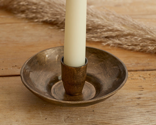 Close-up of Brambourne candle holder showing antique gold finish and rustic iron texture with low-profile heritage styling