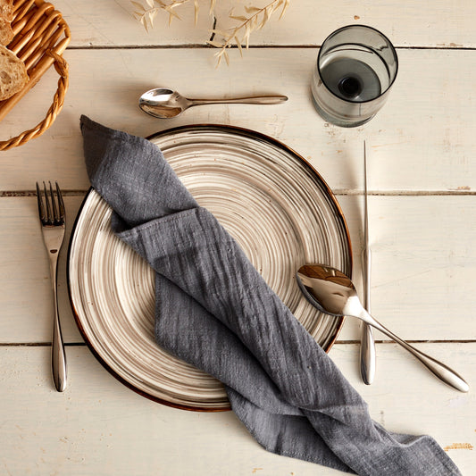 Branston silver stainless steel cutlery set styled in a simple place setting with natural linen and ceramic plate—evokes timeless hosting and countryside charm.