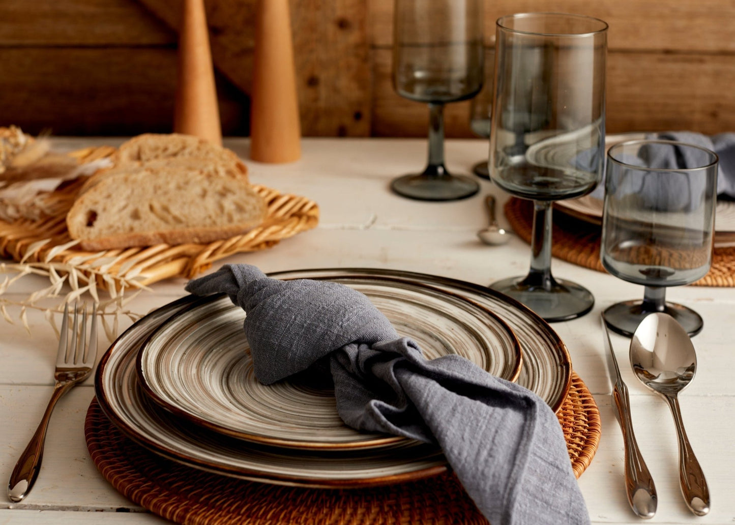 Branston silver stainless steel cutlery set styled on a rustic table with ceramic plates, linen napkin, glasses, and fresh bread—evokes soulful hosting and timeless charm.