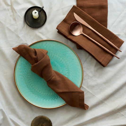 Branwell Brown muslin napkin set in soft cotton, styled on a rustic table with rose gold cutlery, jade pottery plate, and iron candlestick for soulful countryside gatherings and heritage-inspired charm.