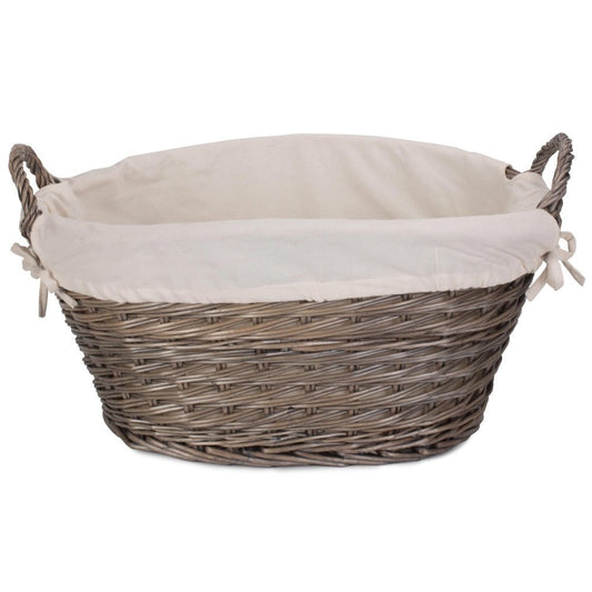 Close-up of The Elmsmere Basket – handwoven wicker laundry carrier with soft white lining, evoking cottage charm and the gentle rhythm of linen in the breeze