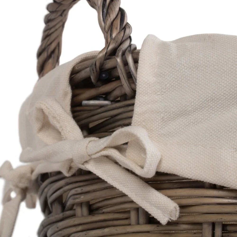 Close-up of woven wicker basket with twisted handle and beige fabric lining tied in a bow