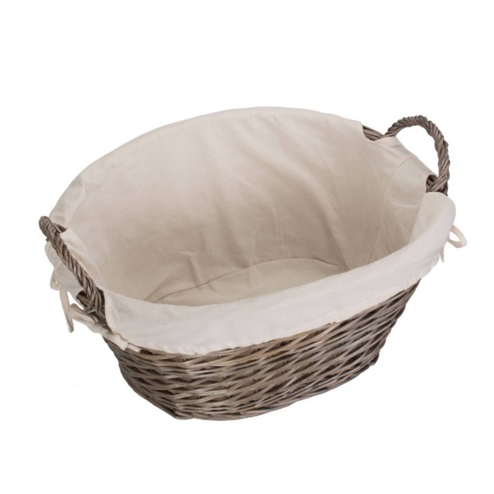 Interior view of The Elmsmere Basket styled in a countryside home – handwoven wicker laundry carrier with soft white lining, evoking cottage charm and linen-filled rituals