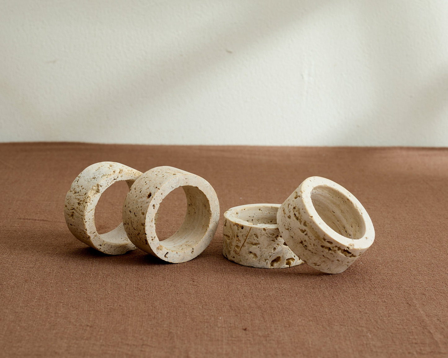Artisan travertine napkin rings with soft veining and natural finish, styled on a rustic table for timeless gatherings and soulful countryside charm.