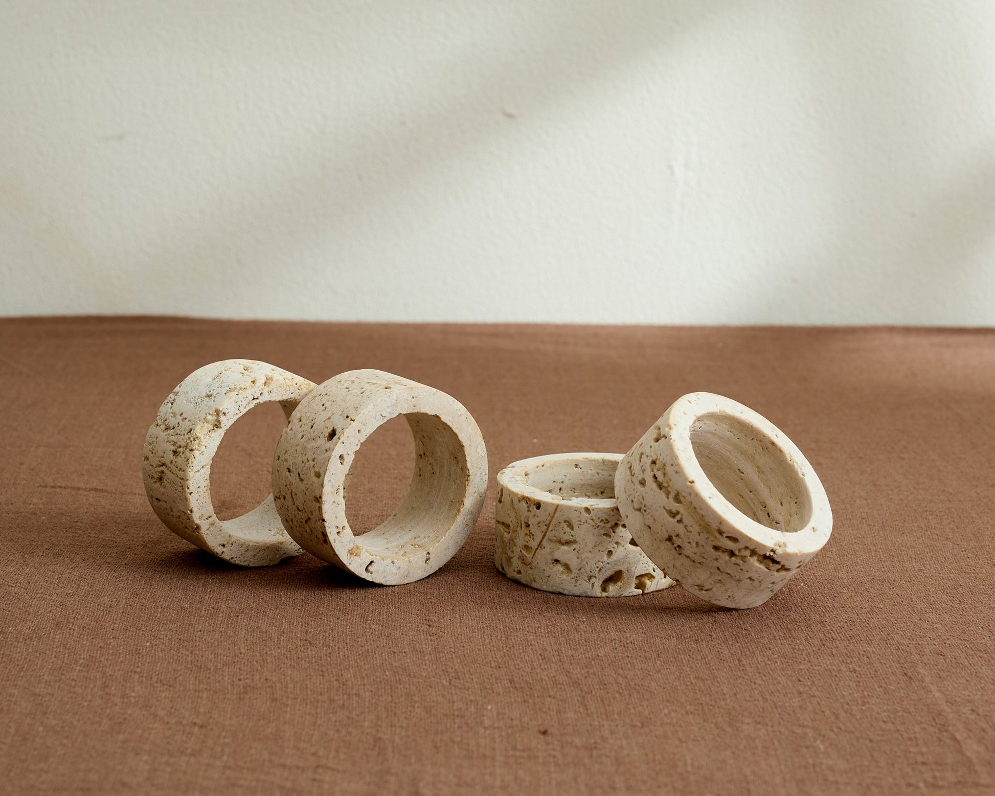 Artisan travertine napkin rings with soft veining and natural finish, styled on a rustic table for timeless gatherings and soulful countryside charm.
