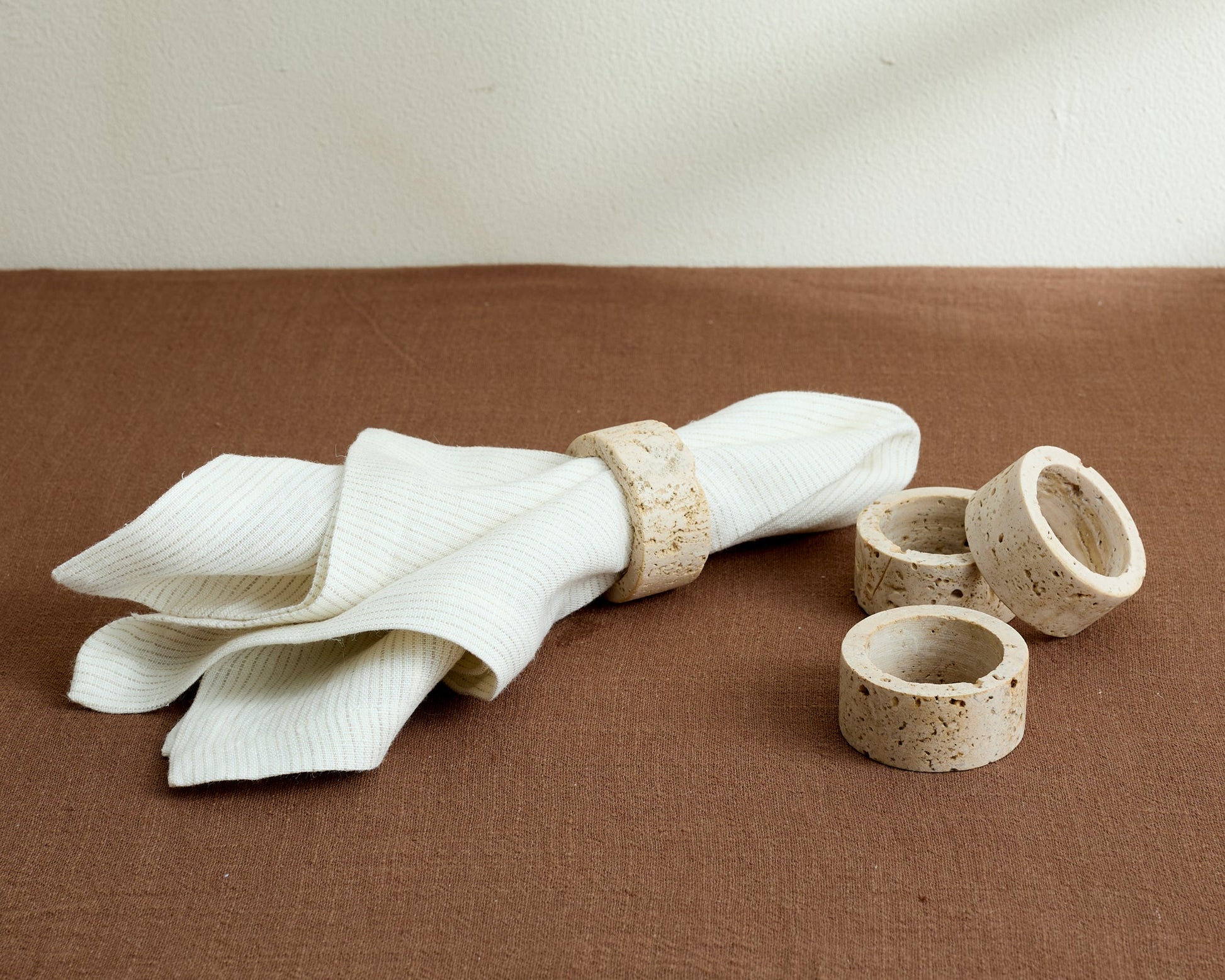 Travertine napkin rings styled on a countryside-inspired tabletop with soft linens and natural textures, evoking timeless charm and soulful hosting.