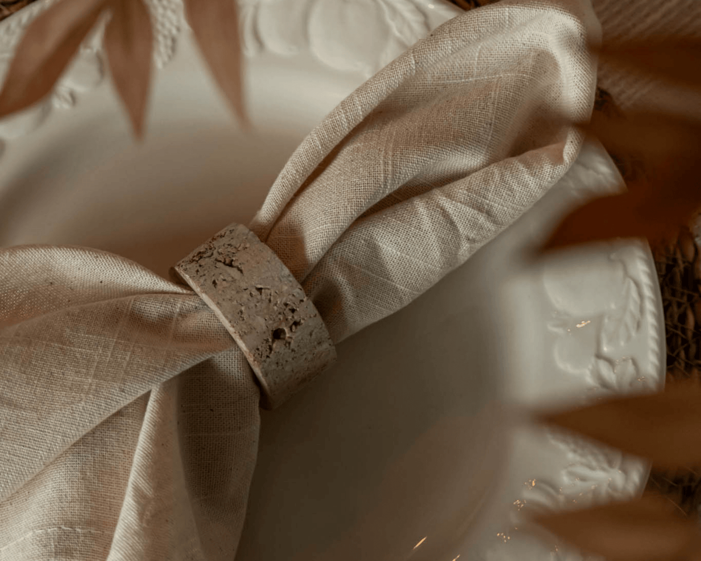 Travertine napkin rings with soft veining and polished finish, styled with natural linens for elegant table settings and timeless countryside charm.