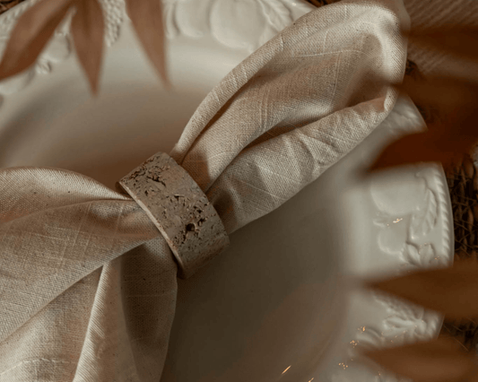Travertine napkin rings with soft veining and polished finish, styled with natural linens for elegant table settings and timeless countryside charm.