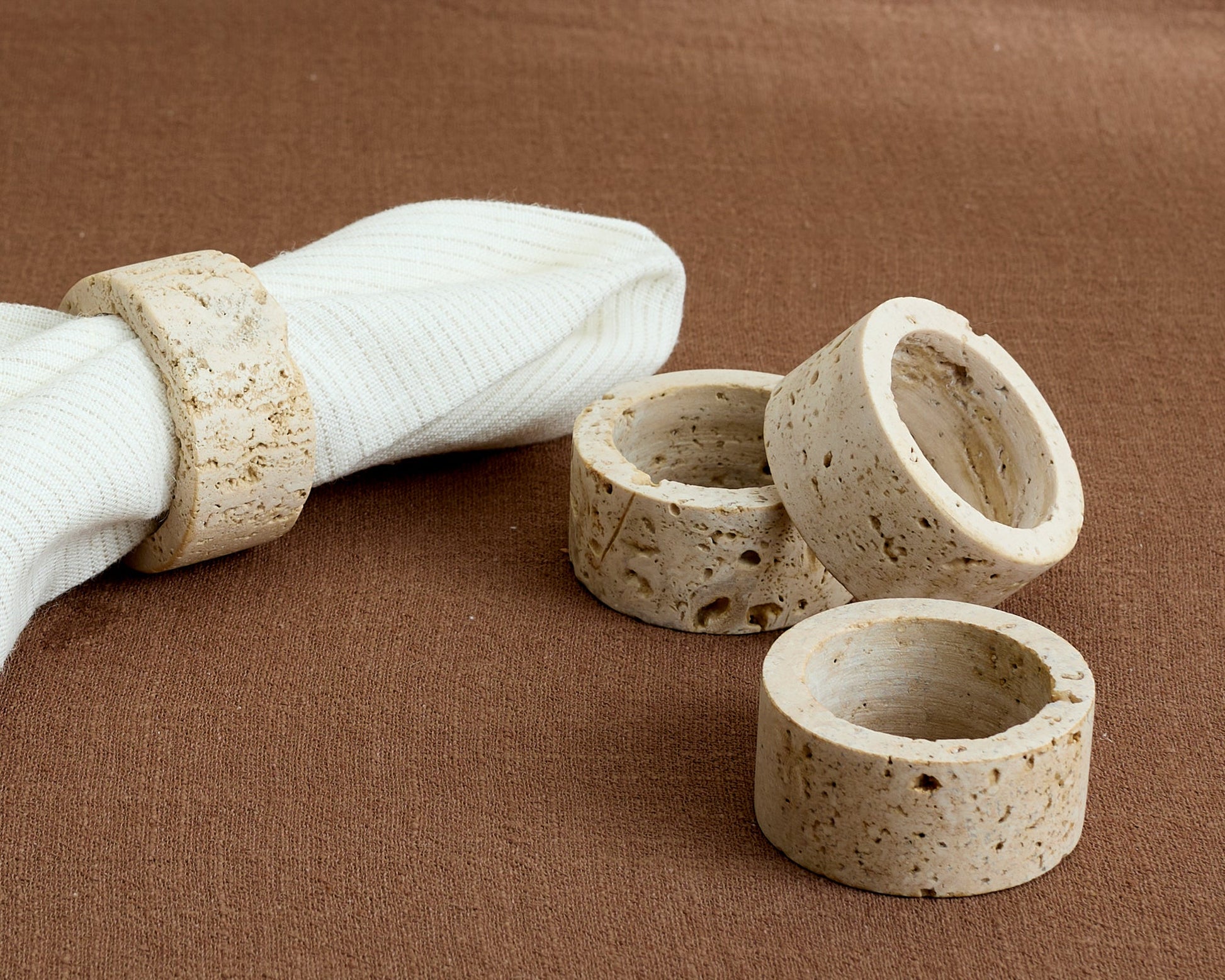 Travertine napkin rings with soft veining and natural finish, styled with rustic linen for timeless table settings and countryside-inspired elegance.