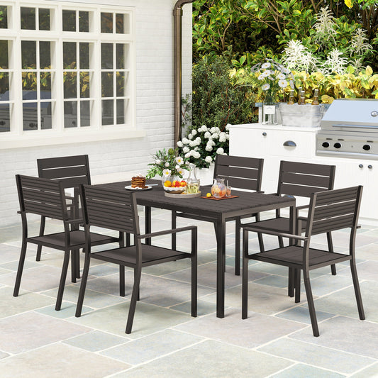 The Hardwick Gathering 7-piece garden dining set with dark brown HDPE slatted table and six stackable steel-frame chairs, styled on a stone patio for timeless outdoor hosting