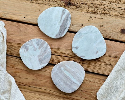 Handcrafted marble coasters with irregular shape and polished finish, reflecting natural countryside charm and artisan craftsmanship.