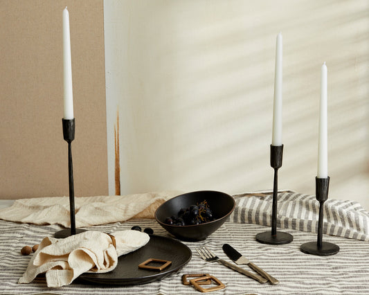 Keswick iron candle trio wrought black holders set styled on dinner table with black plate bowl striped linen and brass napkin rings