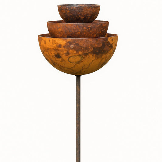 Tiered rusty rain catcher fountain with sculptural bowls on steel stake, placed in UK garden as bird feeder and climbing plant support.