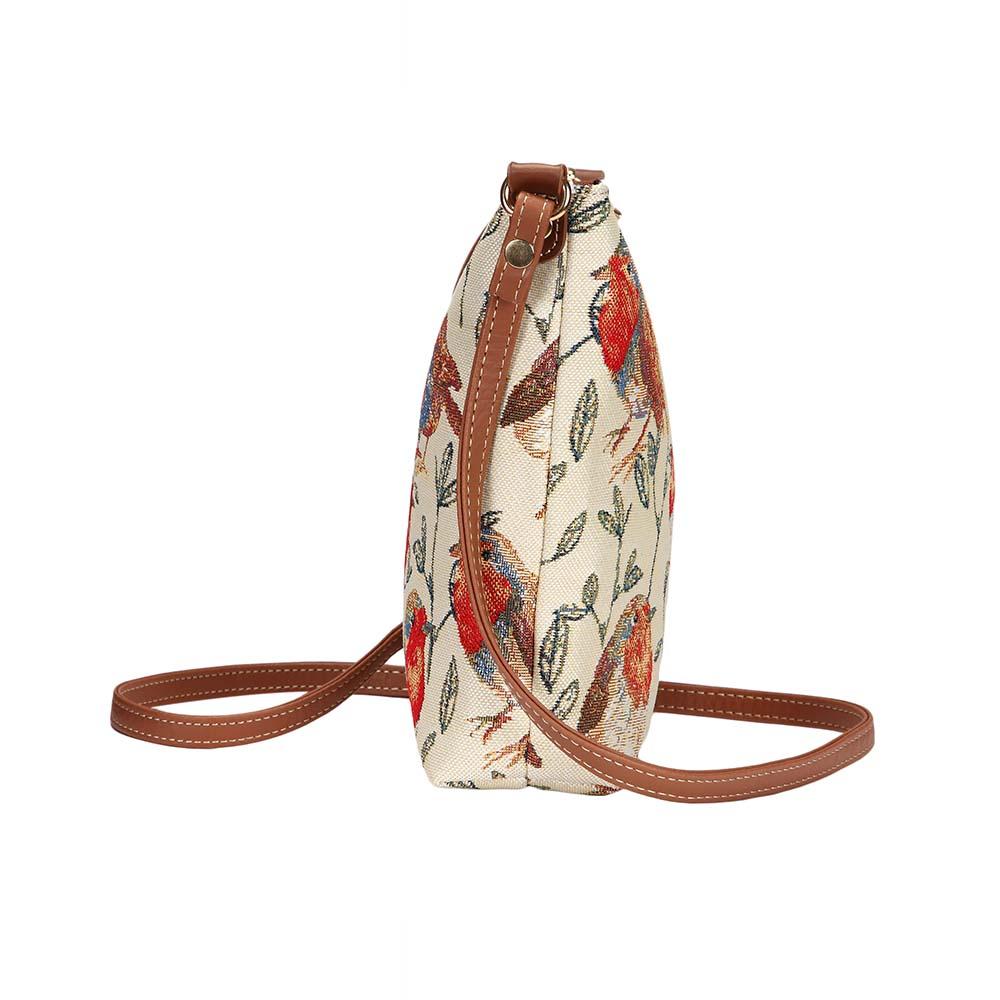 Edge view of Robin sling bag in tapestry fabric showing slim profile, zip closure and vegan leather trim in warm woodland tones