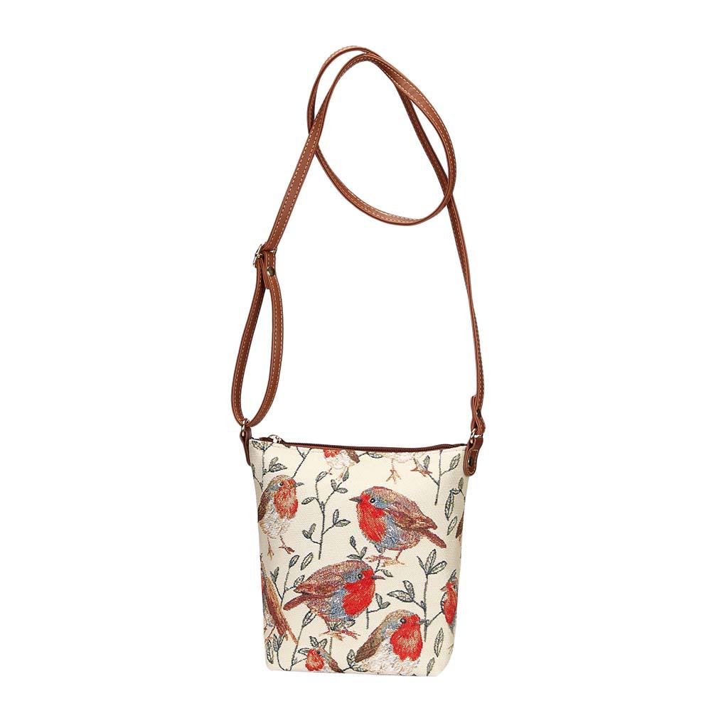 Robin sling bag in tapestry fabric with fully extended adjustable strap, zip closure and vegan leather trim in warm woodland tones