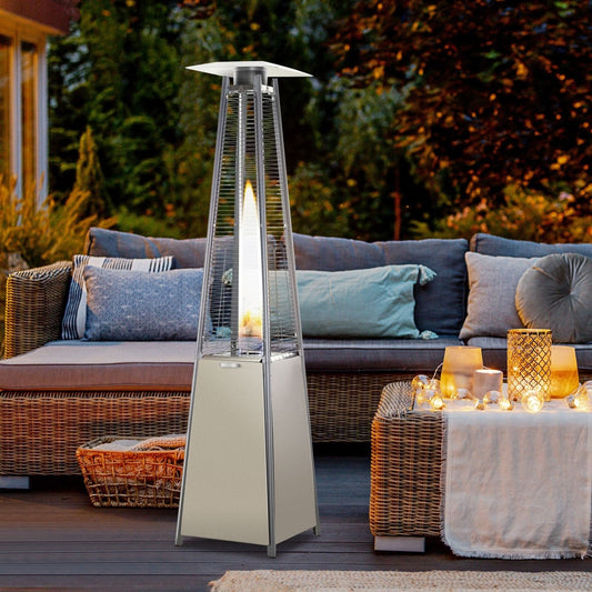 Stainless steel flame tower heater in garden setting, silver freestanding design warming outdoor space for winter gatherings and quiet evenings