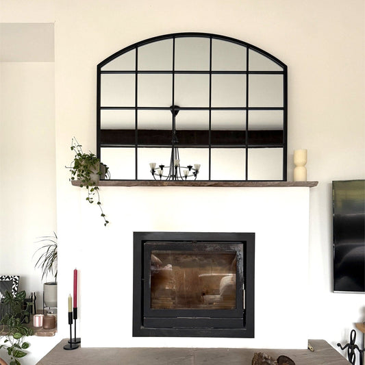 Black arched lattice mirror above fireplace mantel — 95cm x 120cm frame styled for heritage-inspired living rooms and timeless hearthside charm