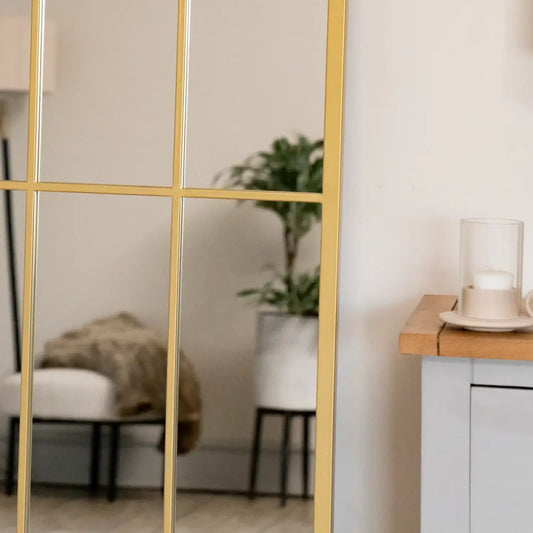 Detail of arched gold mirror frame with lattice design — textured metal finish inspired by heritage architecture