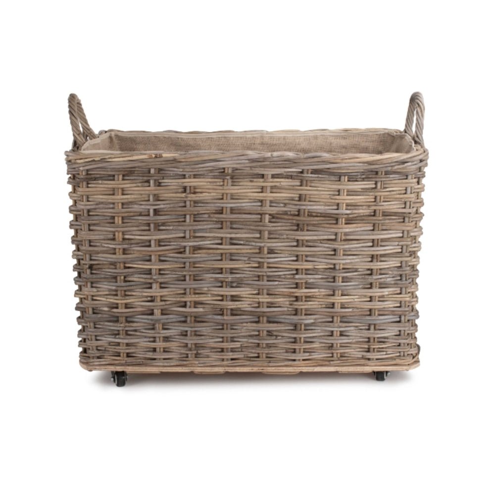 Side view of The Wainsford Log Keeper – antique wash rattan log basket with hessian lining and wheels, crafted for fireside storage and countryside comfort