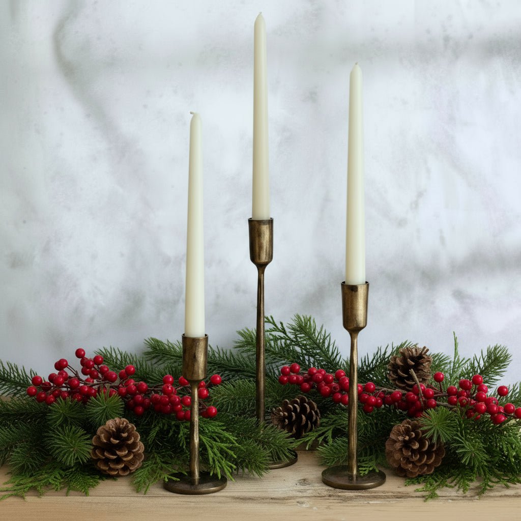 Weldon Iron Candle Holder Set – hand-forged solid iron in antique brass finish, styled with festive garland for rustic table and mantle glow