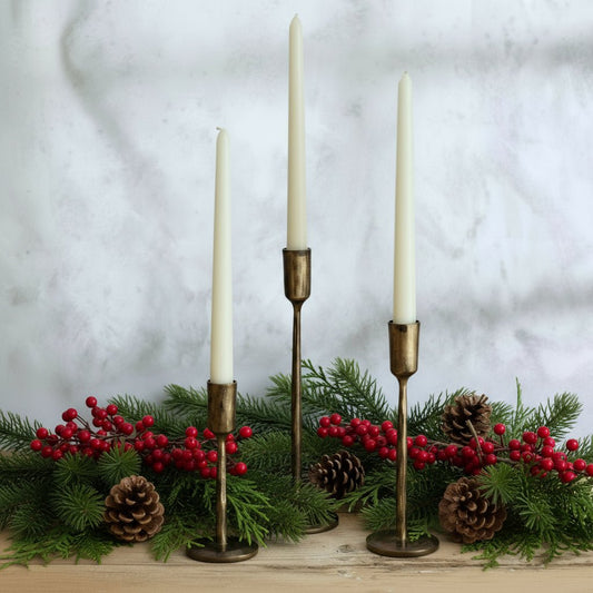 Weldon Iron Candle Holder Set – hand-forged solid iron in antique brass finish, styled with festive garland for rustic table and mantle glow