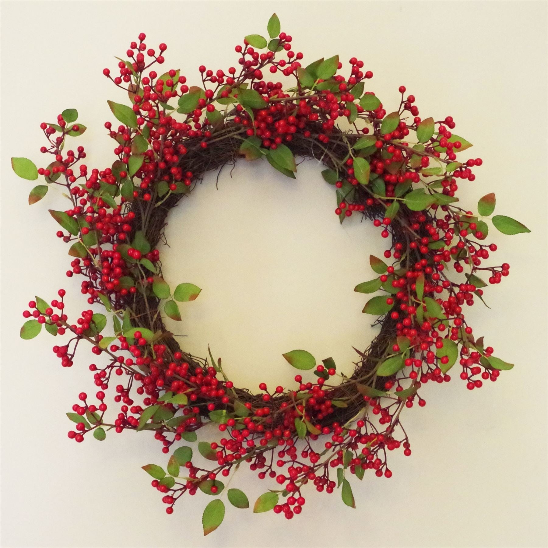The Winthrop redberry wreath styled on interior wall, 24 inch round festive decor with rustic foliage and heritage-inspired seasonal charm