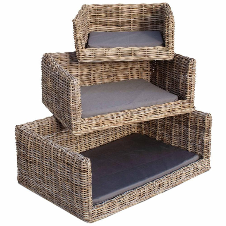 Stacked wicker pet beds with cushions in three sizes, natural rattan texture