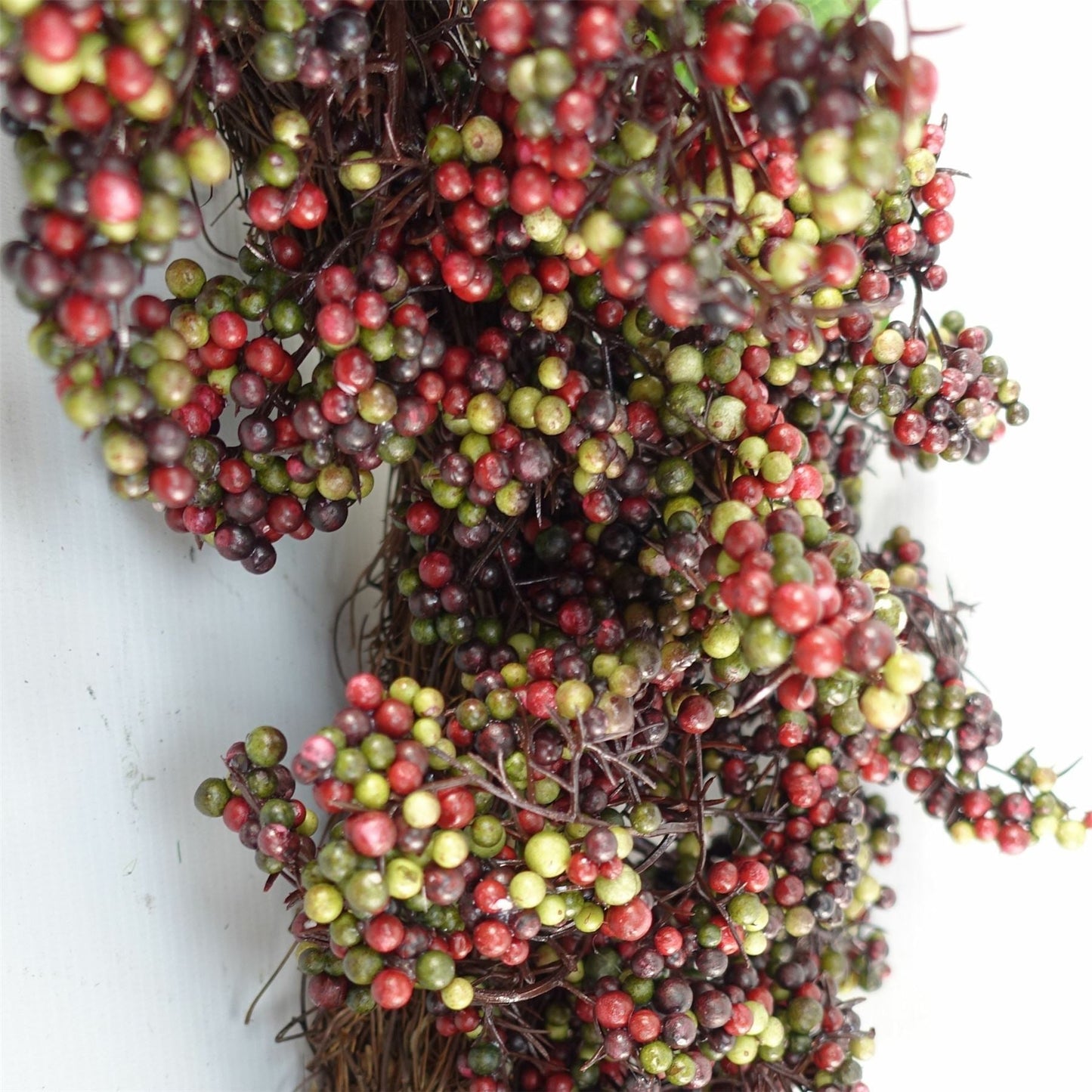 Close up of 55cm black berry wreath with wicker detail — timeless countryside door decoration.