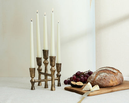 Pembroke iron candelabra five arm candleholder styled on white table with bread board loaf grapes and fig
