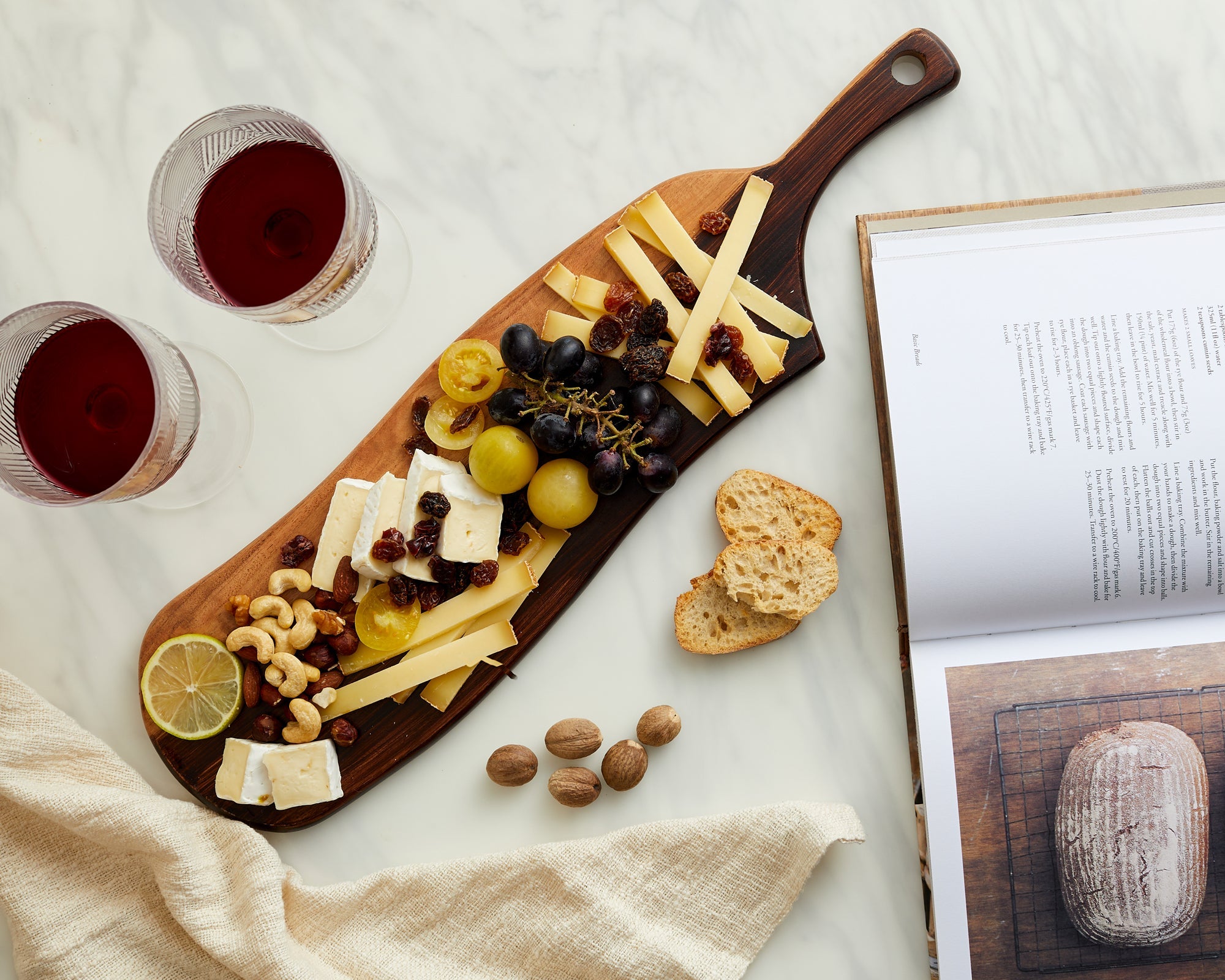 Acacia wood serving board Brambury Rustic styled as cheese board with red wine and recipe book
