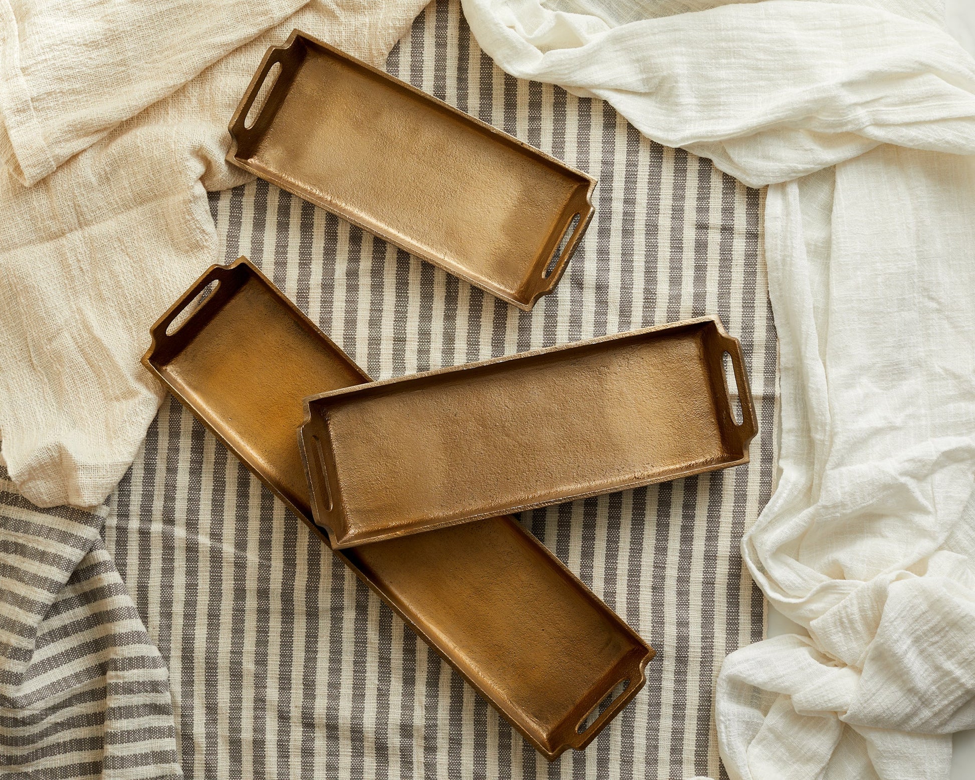 Alderley gold round serving trays all three sizes styled together on linens
