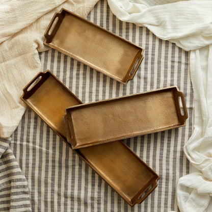 Alderley Gold Tray – brushed gold aluminium in three sizes, styled on soft linen cloth for timeless hosting, rustic elegance, and soulful presentation