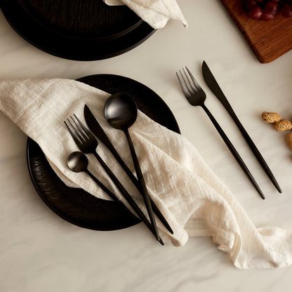 Alverley White cotton napkin styled on a black ceramic plate with black cutlery, all resting on a marble tabletop for refined countryside dining and poetic table layering.