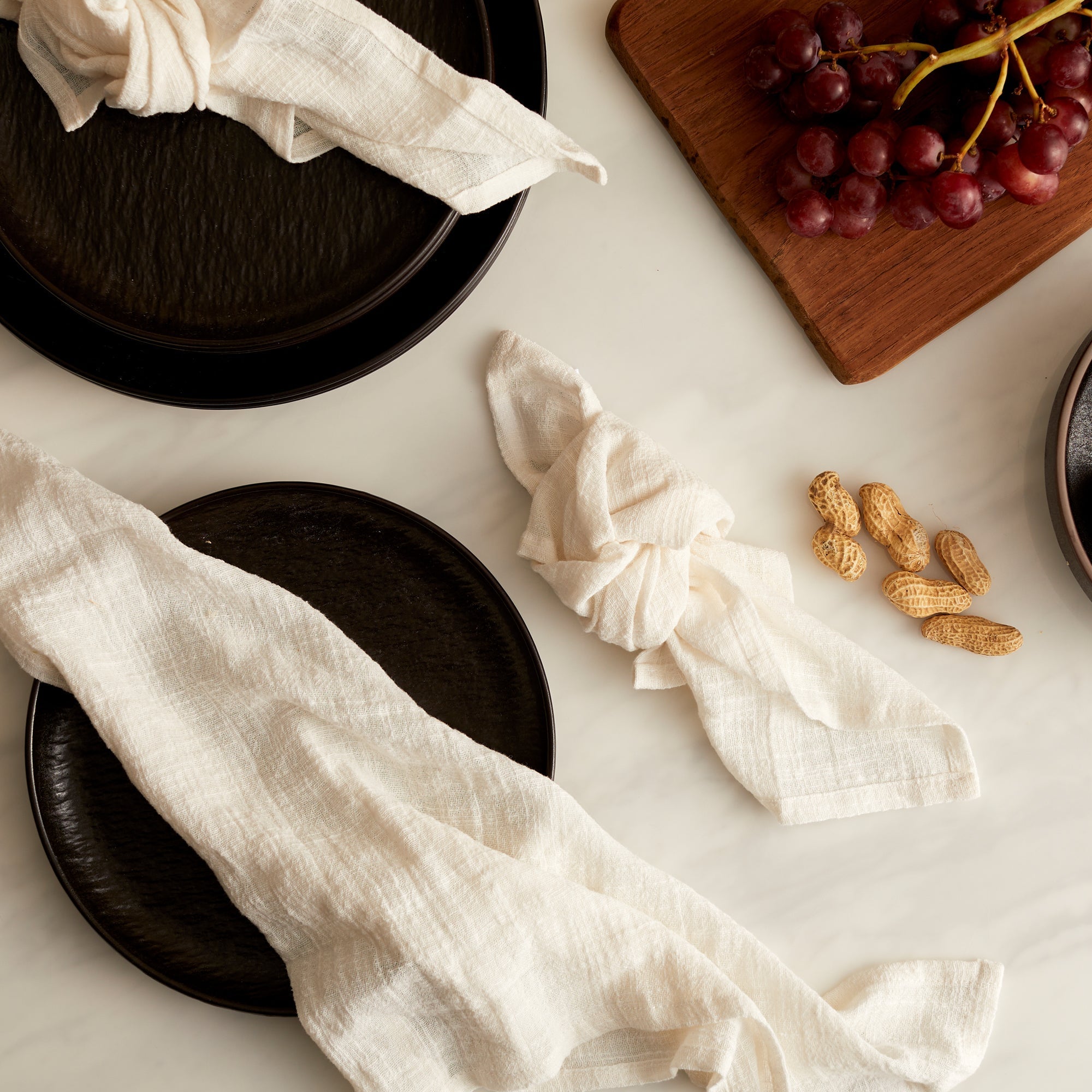Alverley White cotton napkin set styled on a marble table with black ceramic plates and red grapes for poetic countryside dining and soulful table layering.