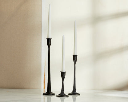 Bloomsbury Iron Black Candle Holder Set of 3 displayed on a table with neutral wall behind