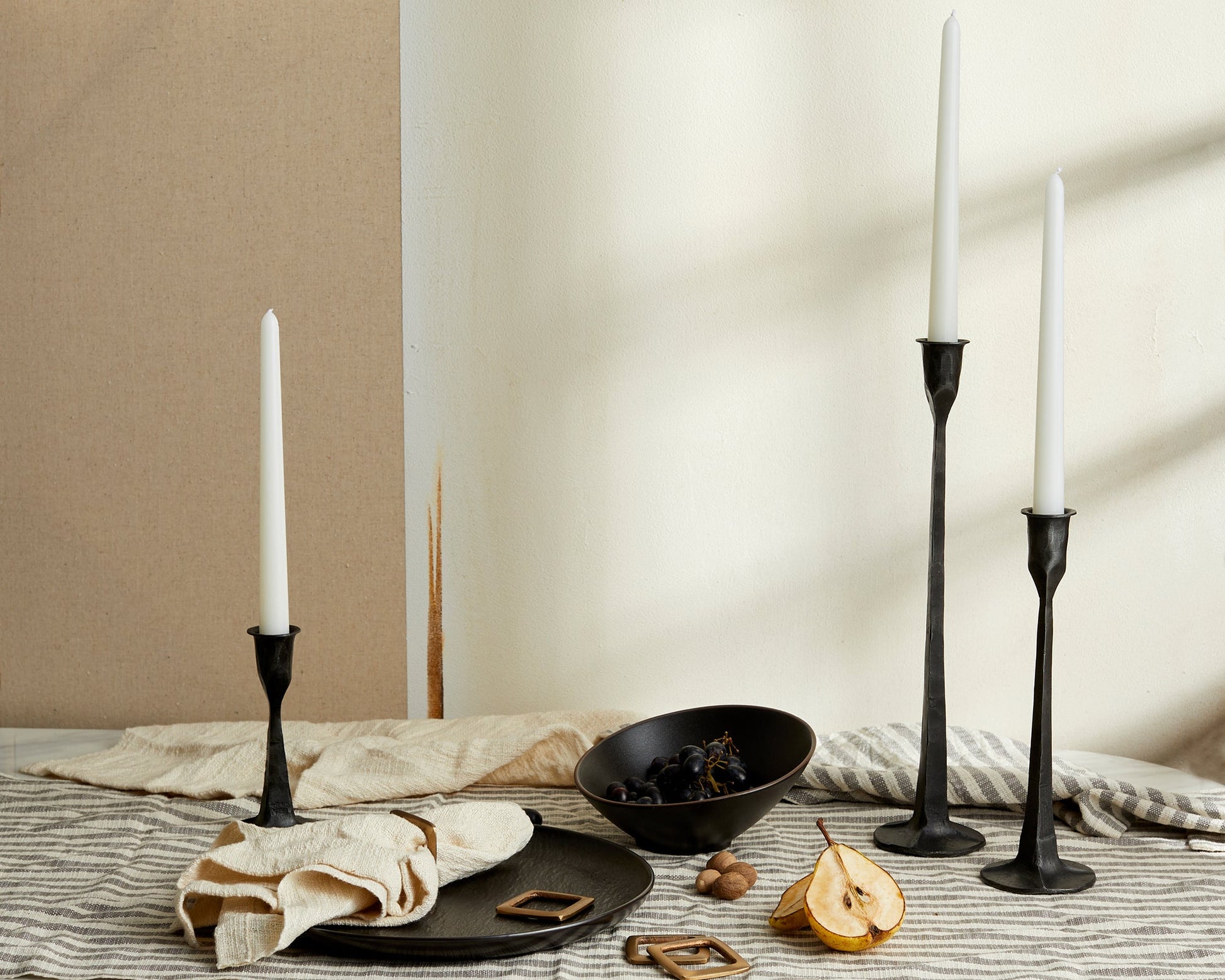 Bloomsbury Iron Black Candle Holder Set of 3 styled on a dining table setting with neutral backdrop