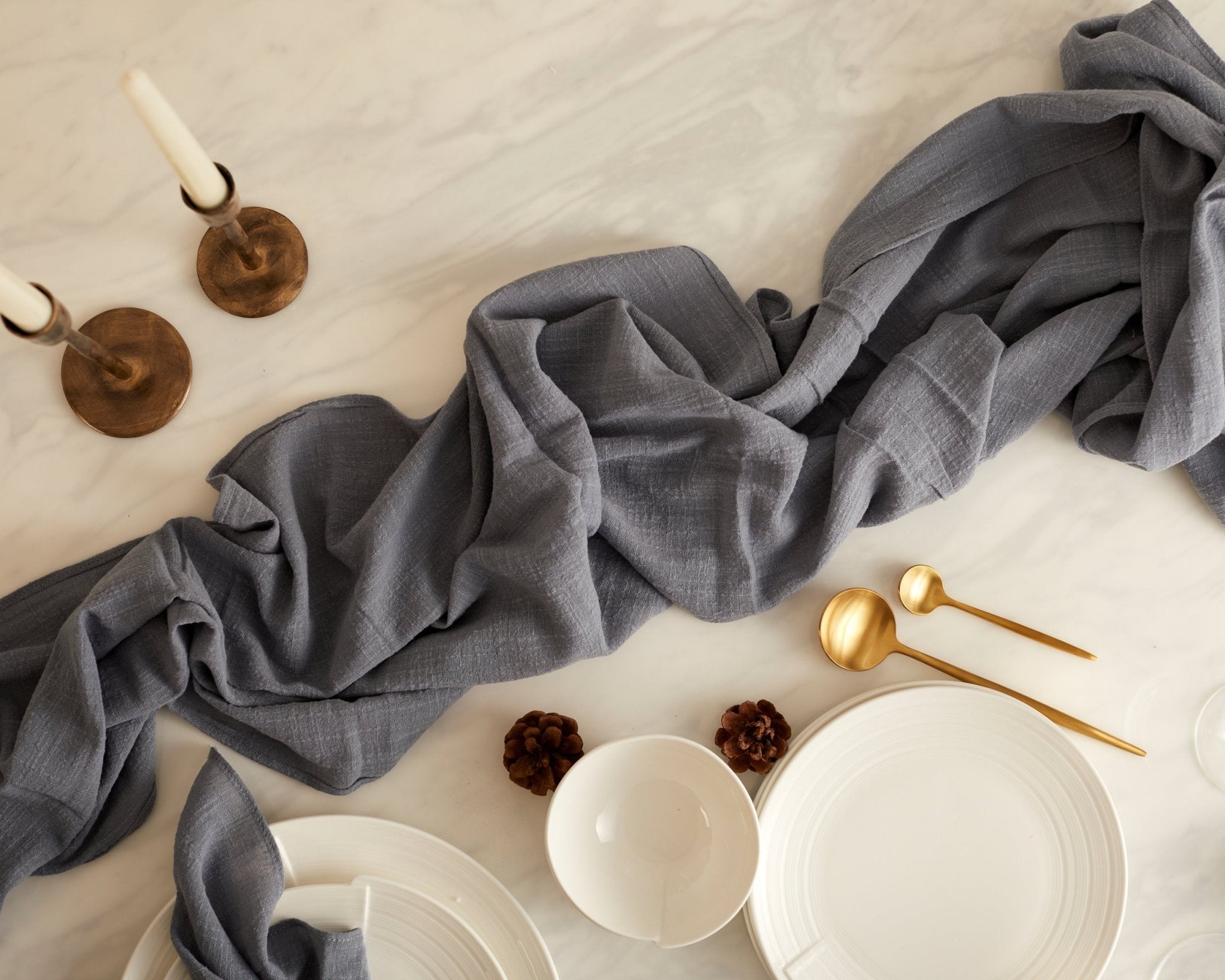 Blue gauze table runner Wendell soft cotton linen laid across centre of rustic dining table
