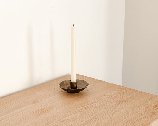 Brambourne candle holder rustic iron taper holder styled on edge of wooden table
