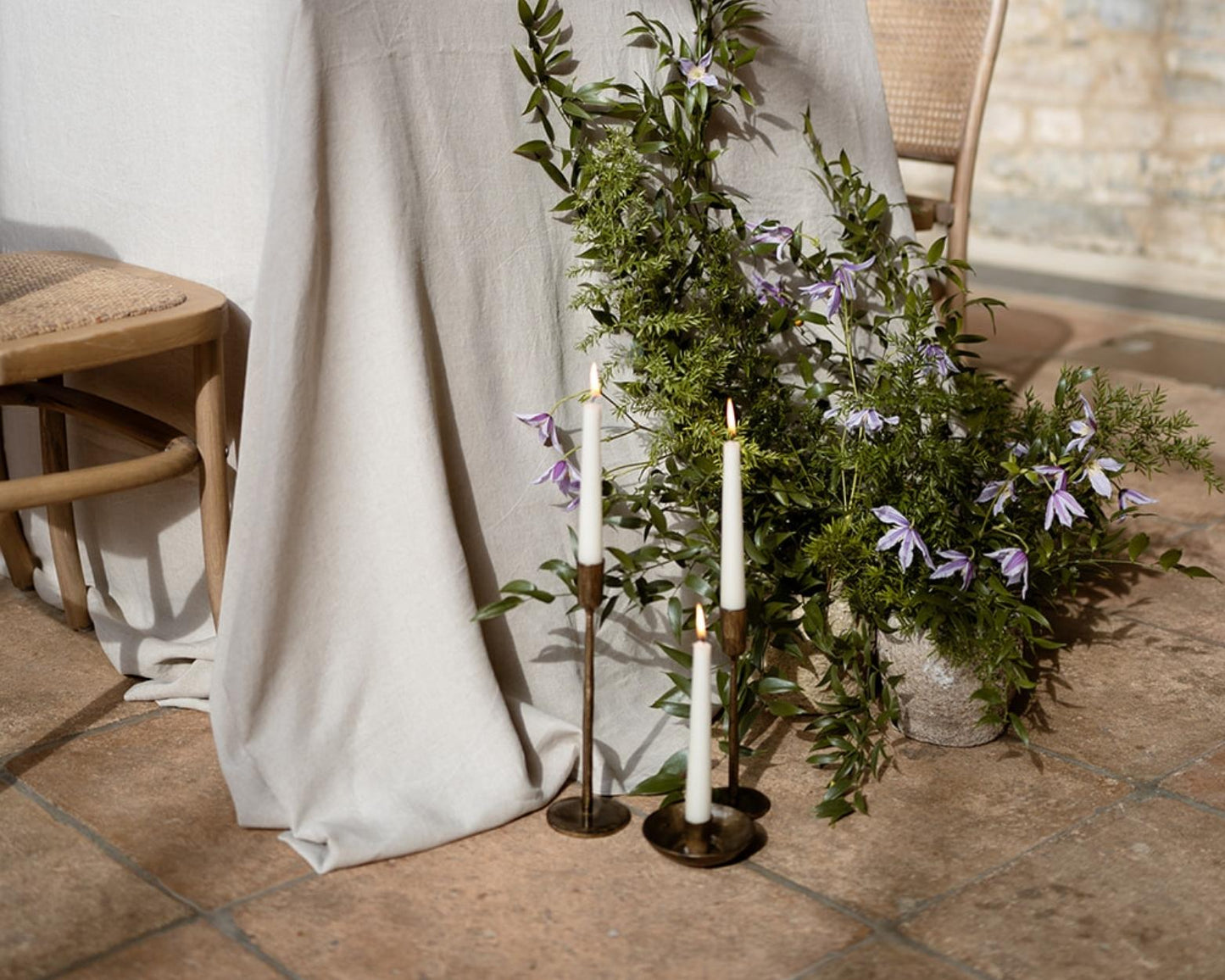 Brambourne candle holder rustic iron taper holder styled on floor with two additional candle holders
