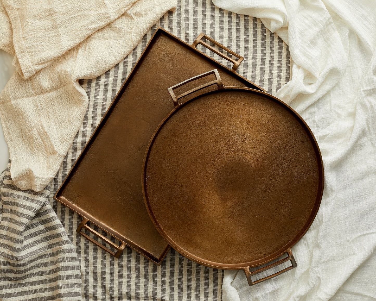 Brontë bronze round hand-finished serving tray with rectangle tray viewed from above together
