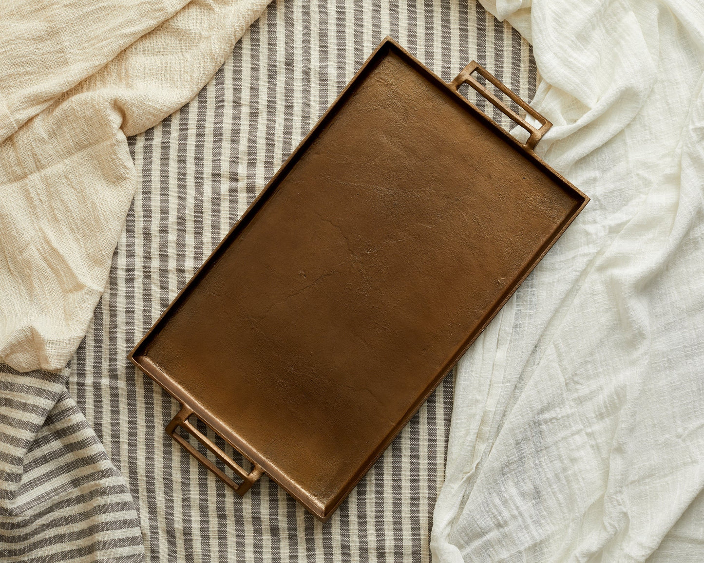 Brontë Bronze rustic serving tray UK styled on top of a layer of linen
