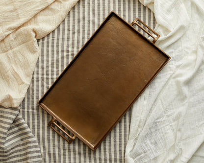 Brontë Bronze rustic serving tray UK styled on top of a layer of linen
