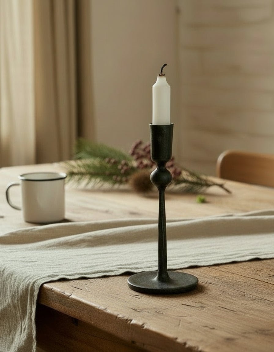 Coalbrook iron black candle holder on farmhouse table with table runner, festive sprigs and enamel mug