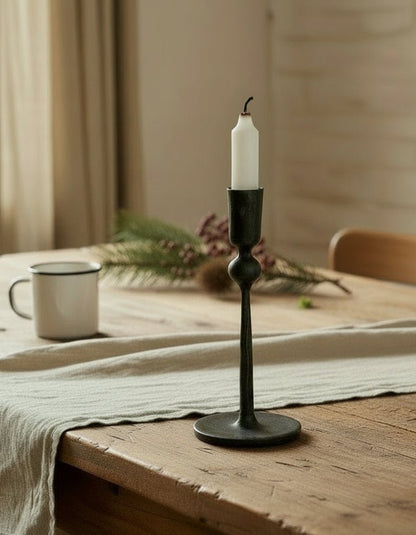 Coalbrook iron black candle holder on farmhouse table with table runner, festive sprigs and enamel mug