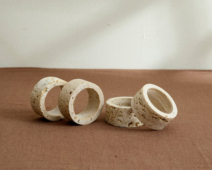 Artisan travertine napkin rings with soft veining and natural finish, styled on a rustic table for timeless gatherings and soulful countryside charm.